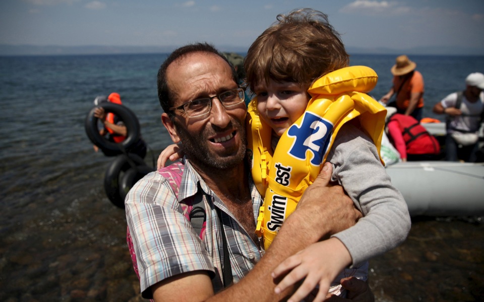 Refugees cheer, pray, embrace strangers as they reach Greece