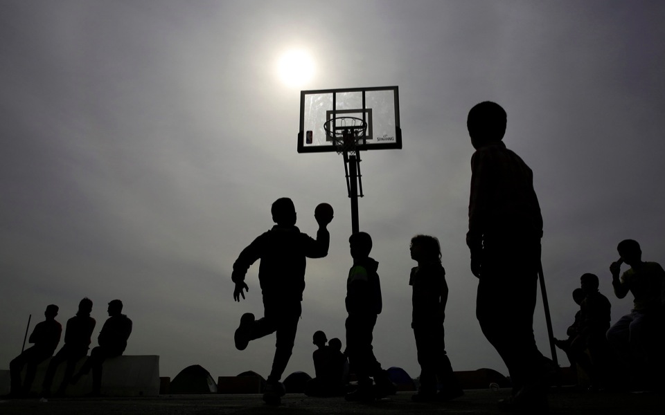 Refugee boys play basketball at Piraeus port