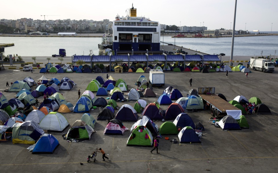 Greece tries to coax camped-out migrants into center as tourist season nears