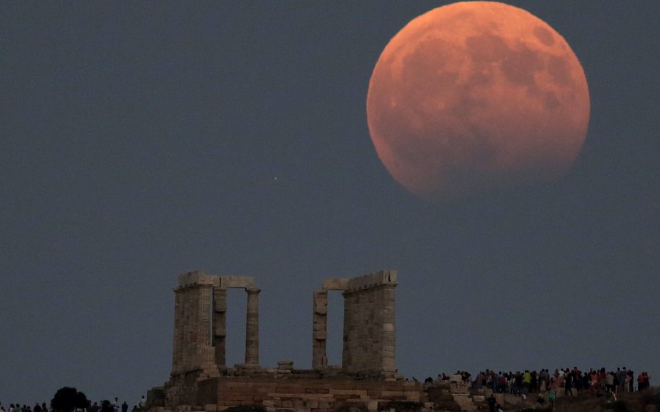 August full moon with partial eclipse over the Temple of Poseidon
