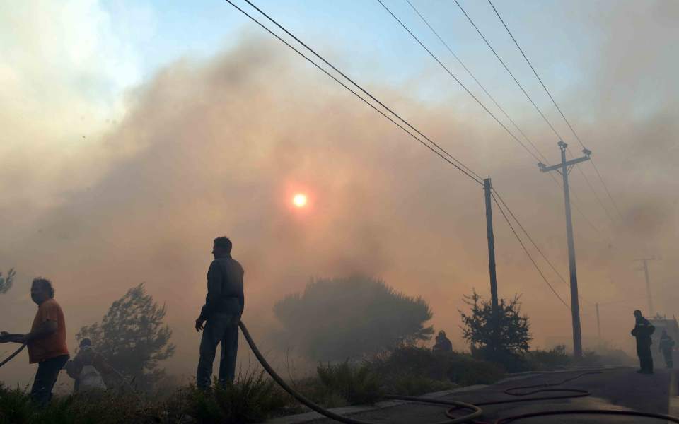 Large fire burns for second day, threatens homes near Athens