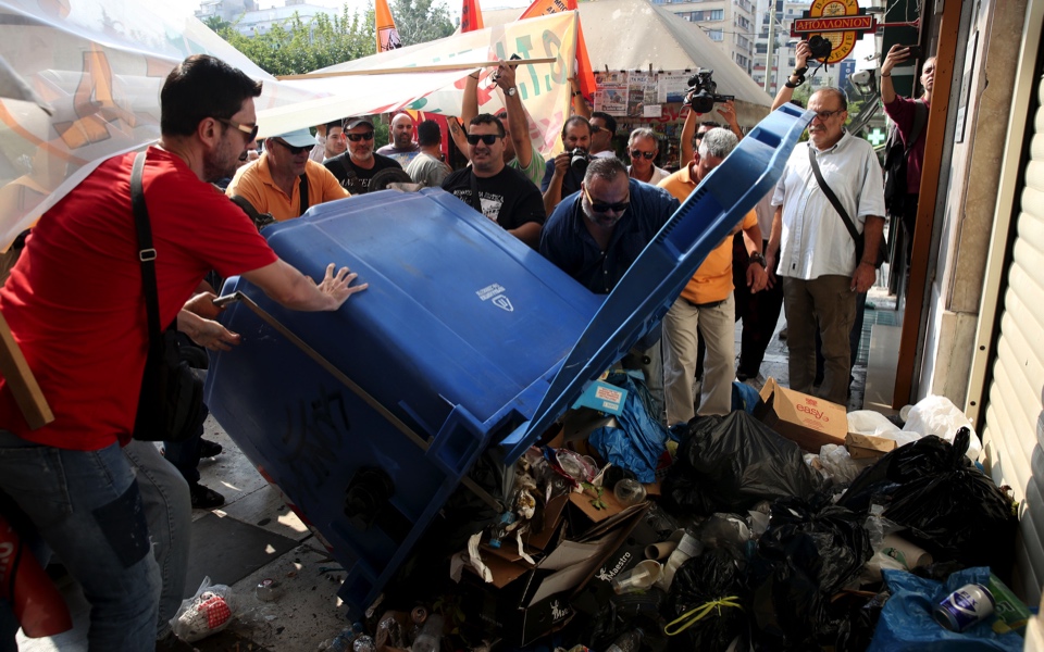 Protesting workers unload garbage outside ministry