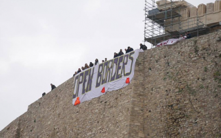 Activists hang banners from the Acropolis