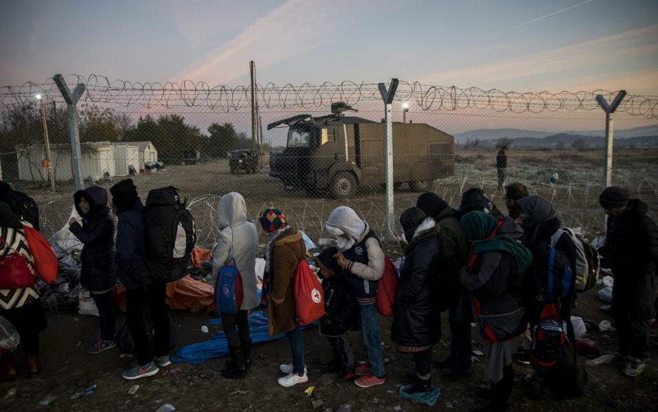 Migrants stuck in Greek makeshift camp vow to stay put