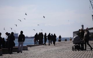 Pedestrians enjoy the sun on Thessaloniki seafront