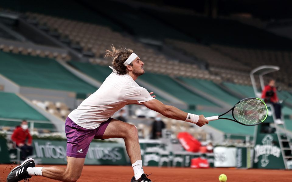 Steely Tsitsipas keeps cool to beat Isner in four sets